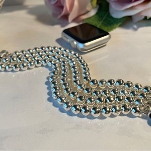 Silver beaded Apple Watch band.